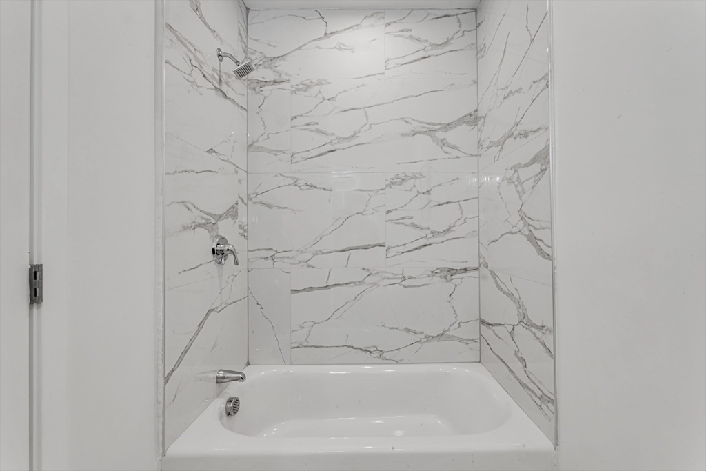 3992 Washington Street, Unit 302 Boston, MA 02131 - Photo 23 of 29 a bathroom with a bathtub