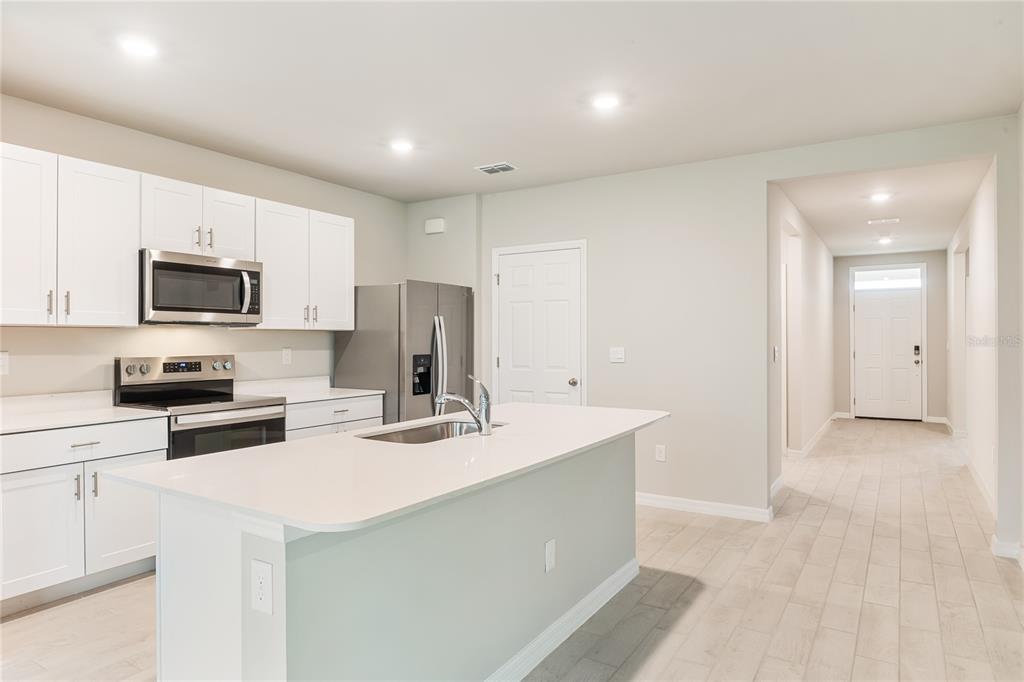 9504 Turtle Grass Circle Punta Gorda, FL 33950 - Photo 4 of 21 a kitchen with a sink a stove a refrigerator and white cabinets