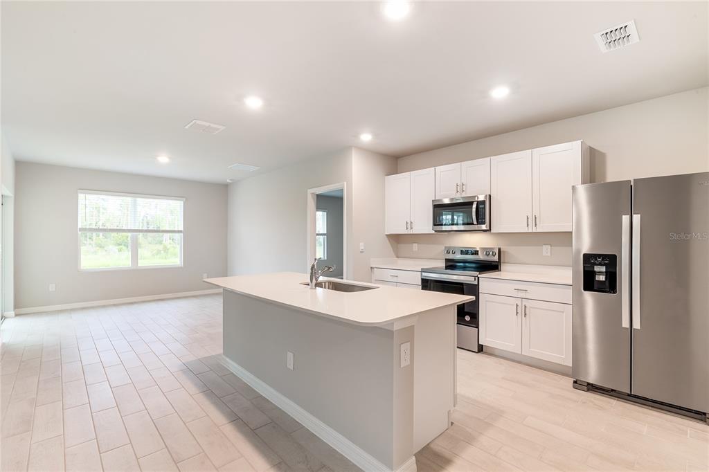 9504 Turtle Grass Circle Punta Gorda, FL 33950 - Photo 5 of 21 a kitchen with a sink a refrigerator and a stove top oven
