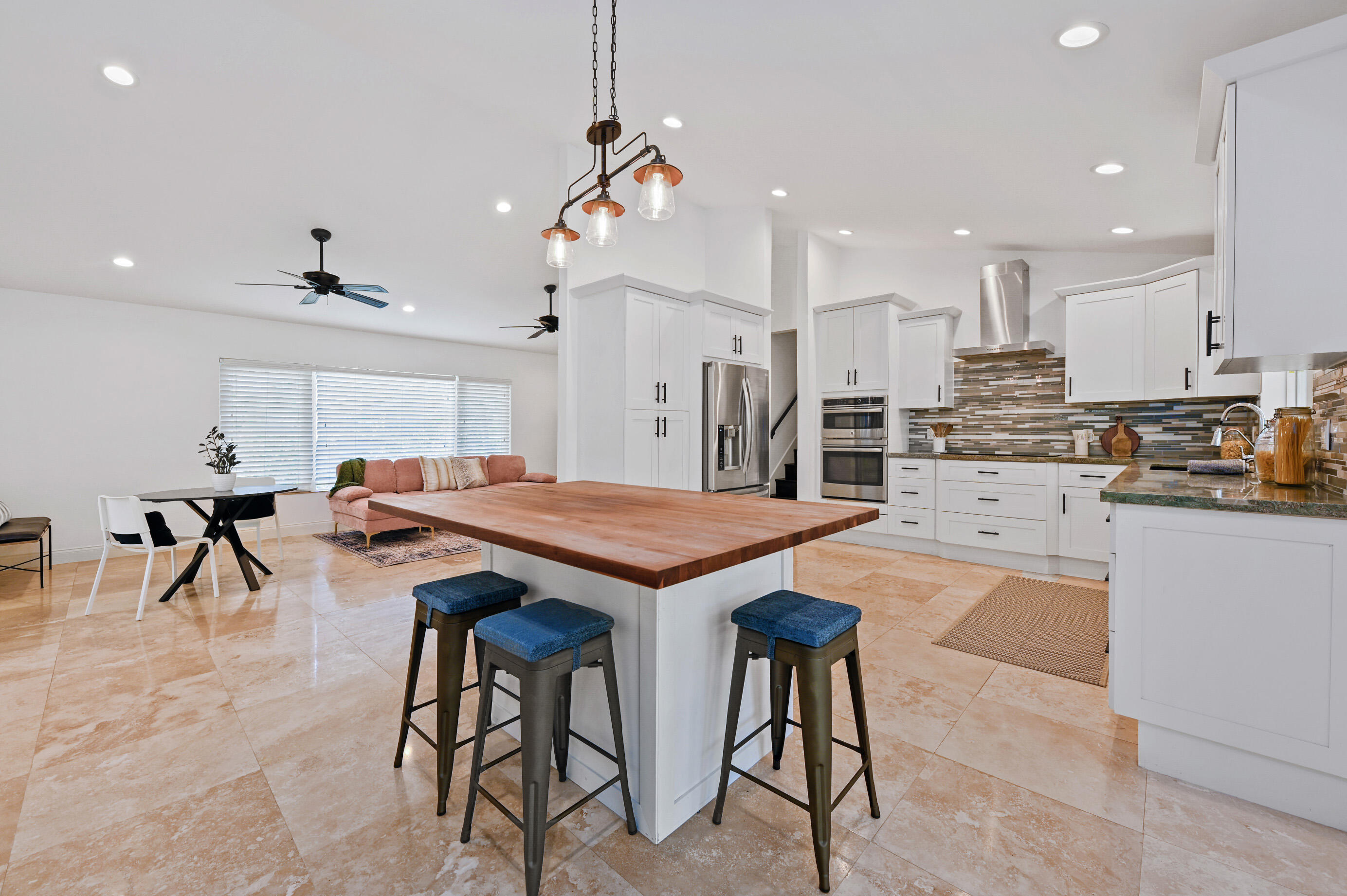 600 Mission Hill Road Boynton Beach, FL 33435 - Photo 11 of 42 a kitchen with stainless steel appliances kitchen island granite countertop a table chairs sink and cabinets