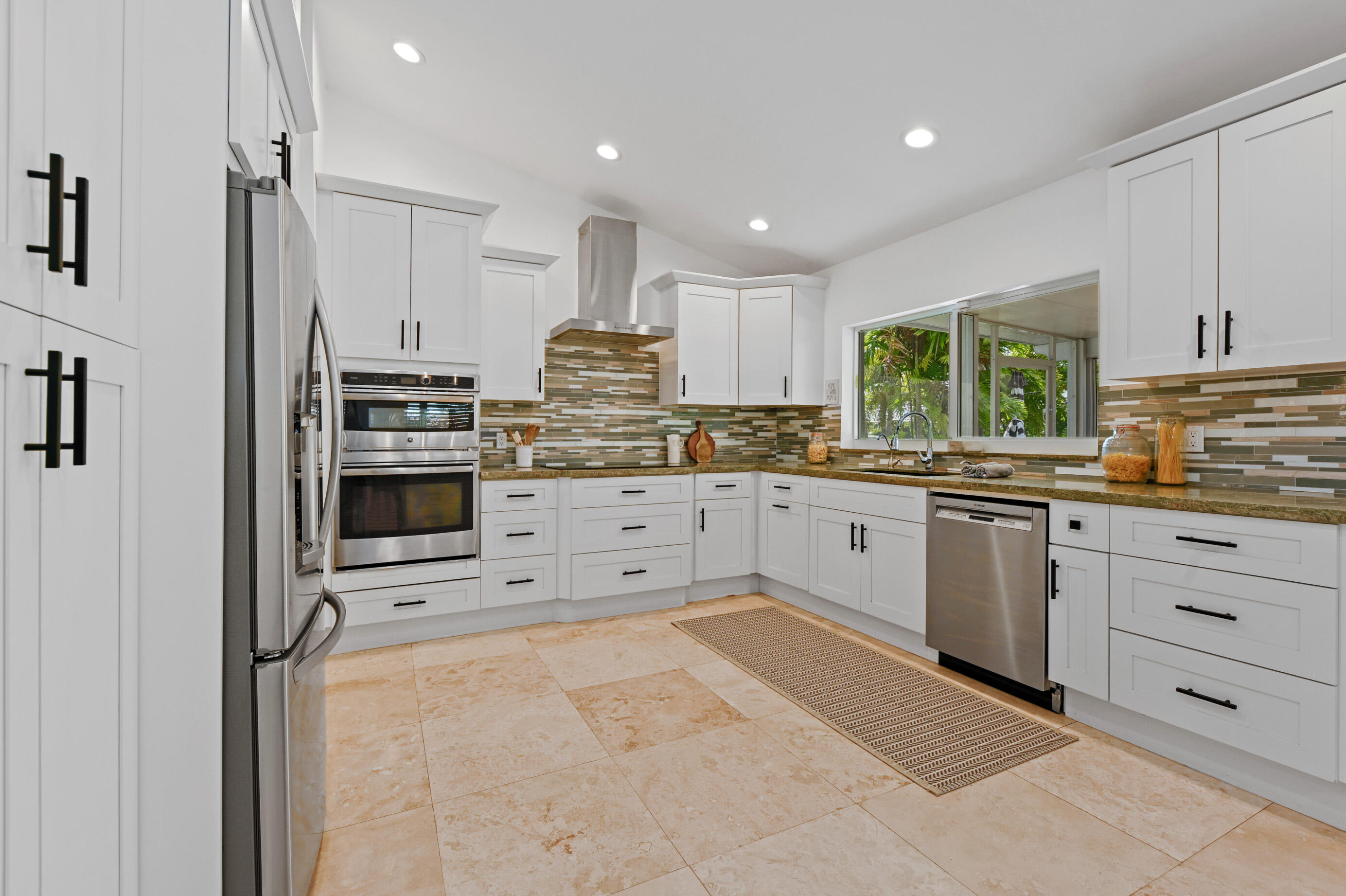 600 Mission Hill Road Boynton Beach, FL 33435 - Photo 12 of 42 a kitchen with granite countertop a stove sink and cabinets