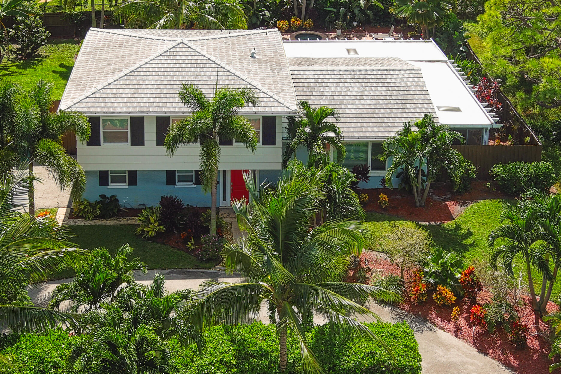600 Mission Hill Road Boynton Beach, FL 33435 - Photo 5 of 42 a view of a white house with a yard and potted plants