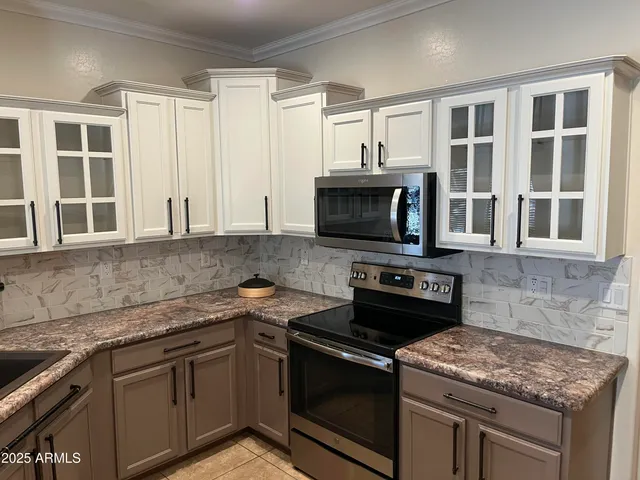 a kitchen with a sink a stove and cabinets