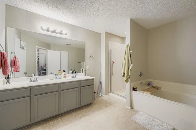 a spacious bedroom with a bed and a chandelier