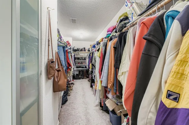 a spacious bedroom with a bed and a chandelier
