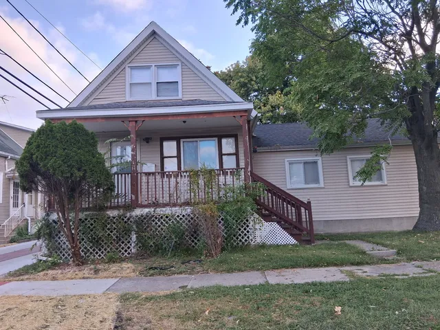 a front view of a house with a yard and potted plants