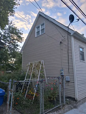 a backyard of a house with plants and white walls