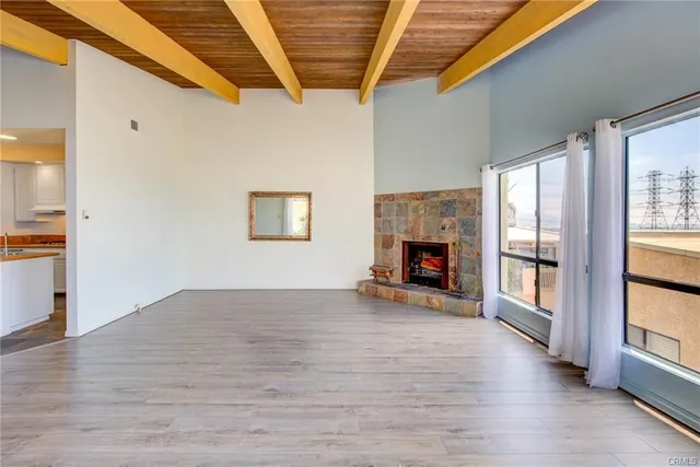 a view of empty room with wooden floor and fireplace
