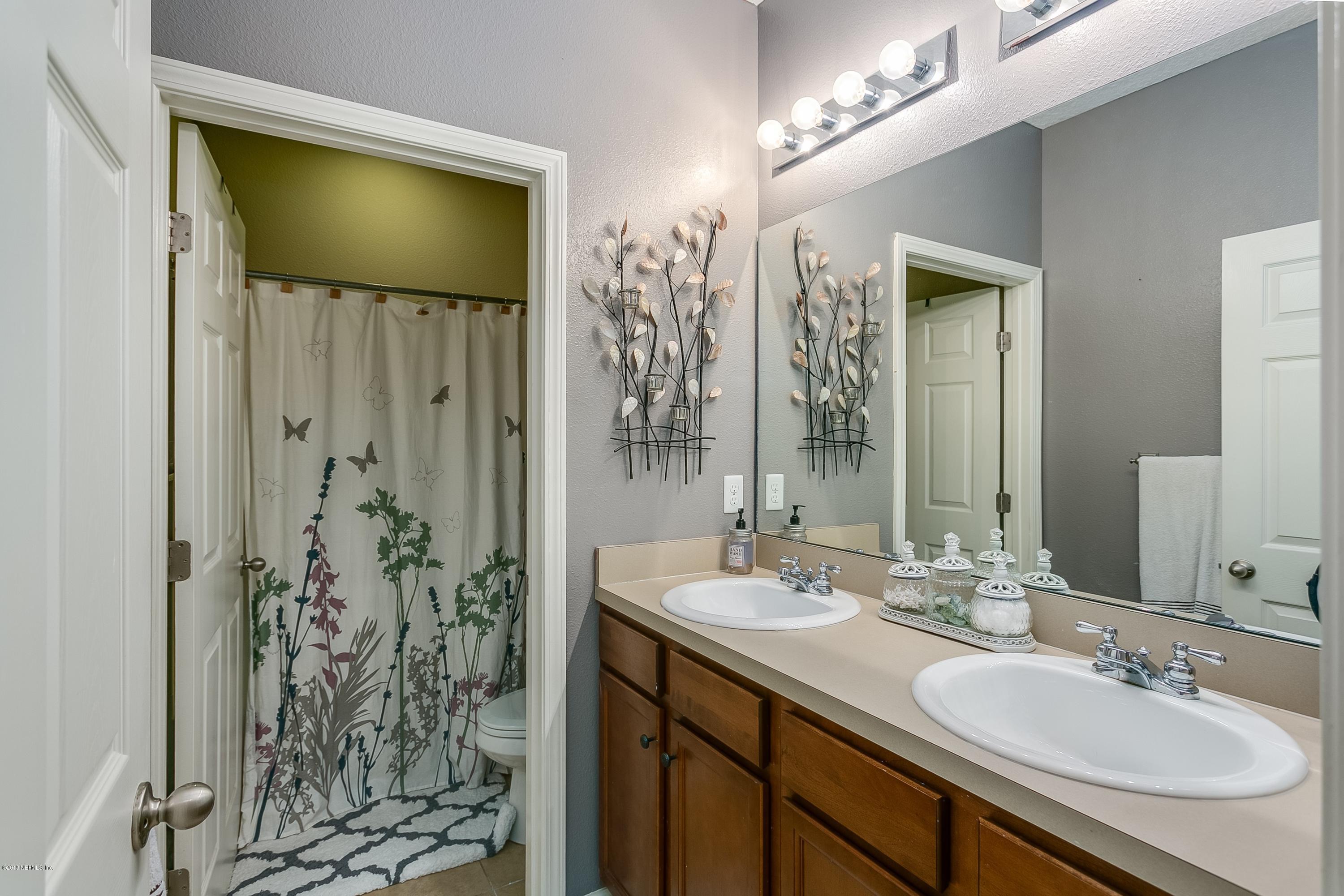 16378 Tisons Bluff Road Jacksonville, FL 32218 - Photo 18 of 24 a bathroom with a granite countertop sink a shower and a mirror