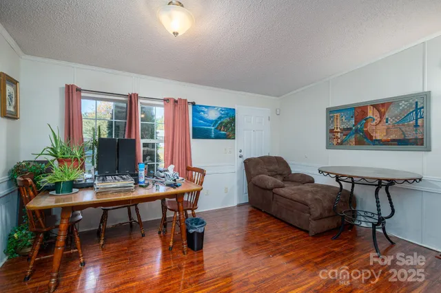 a living room with furniture and a flat screen tv with wooden floor