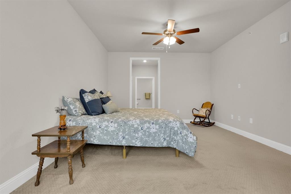 651 Watters Road, Unit 2105 Allen, TX 75013 - Photo 19 of 32 a bedroom with a bed and a chandelier