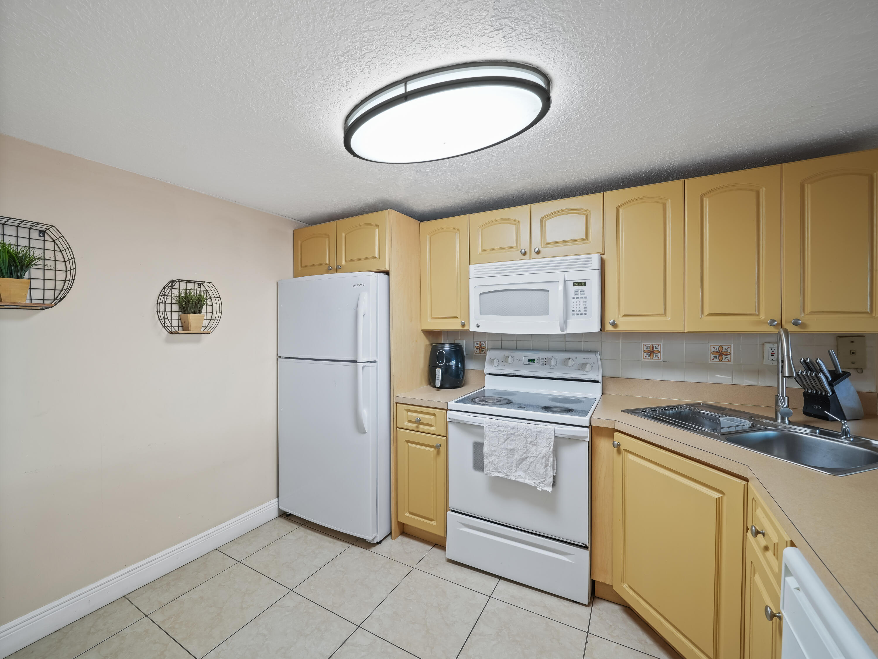 3672 Southwest 59th Terrace, Unit 73 Davie, FL 33314 - Photo 11 of 39 a kitchen with a refrigerator sink and cabinets