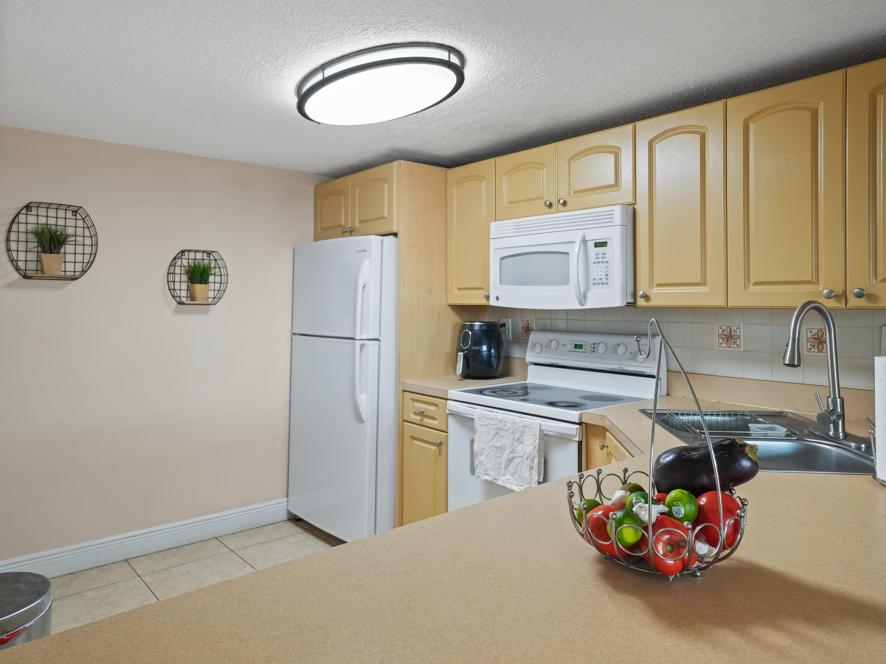 3672 Southwest 59th Terrace, Unit 73 Davie, FL 33314 - Photo 12 of 39 a kitchen with stainless steel appliances a refrigerator sink and cabinets