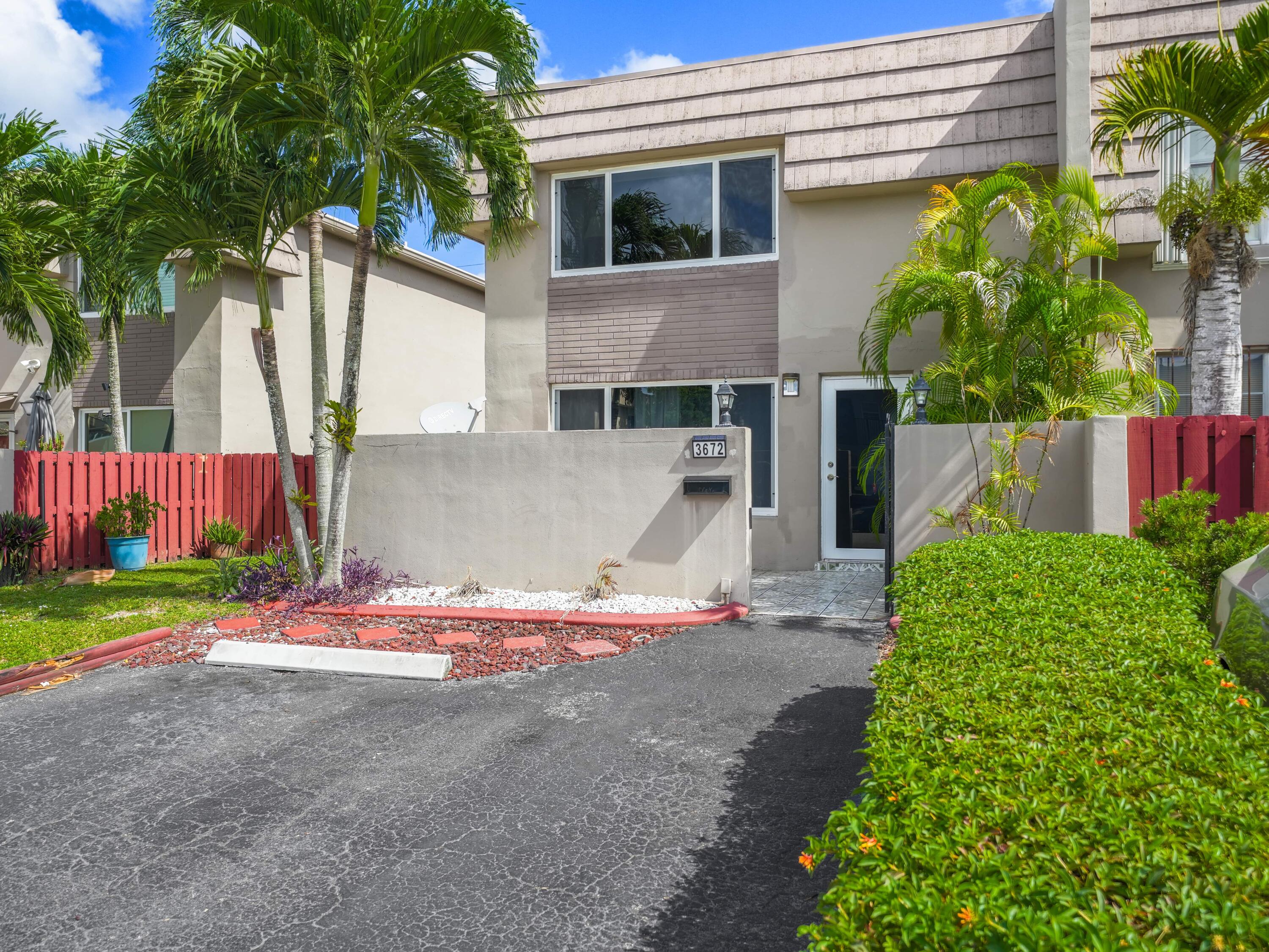 3672 Southwest 59th Terrace, Unit 73 Davie, FL 33314 - Photo 2 of 39 a white house with a yard and plants