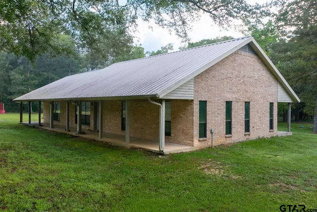 a view of a house with a yard and porch