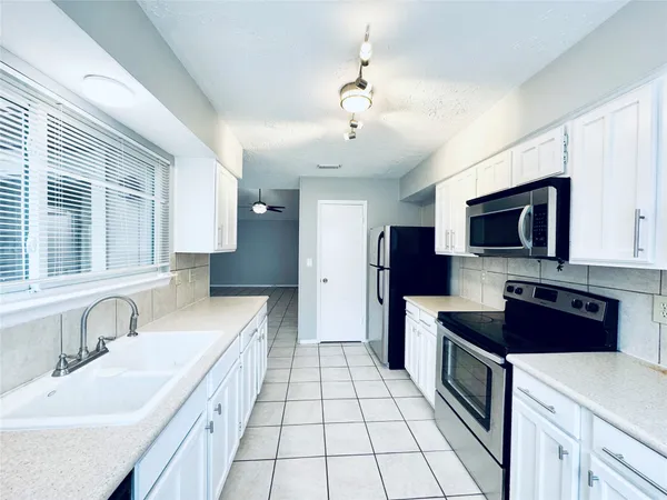 a large kitchen with stainless steel appliances granite countertop a sink and a stove