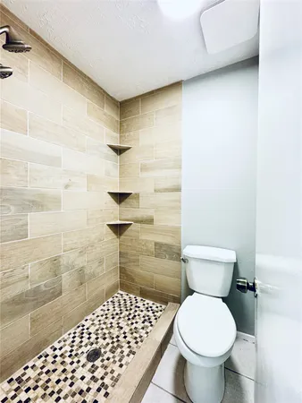a bathroom with a toilet and a shower