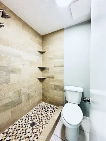 a bathroom with a toilet and a shower