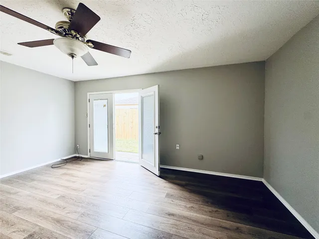 a view of room with a ceiling fan and wooden floor