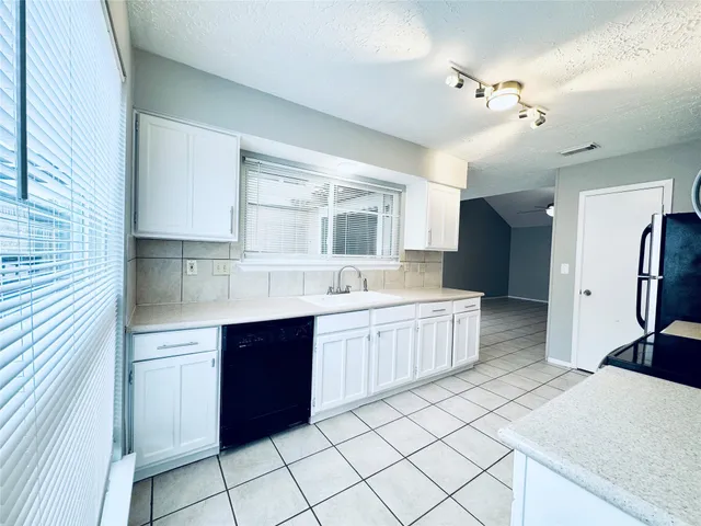 a kitchen with a sink window and cabinets