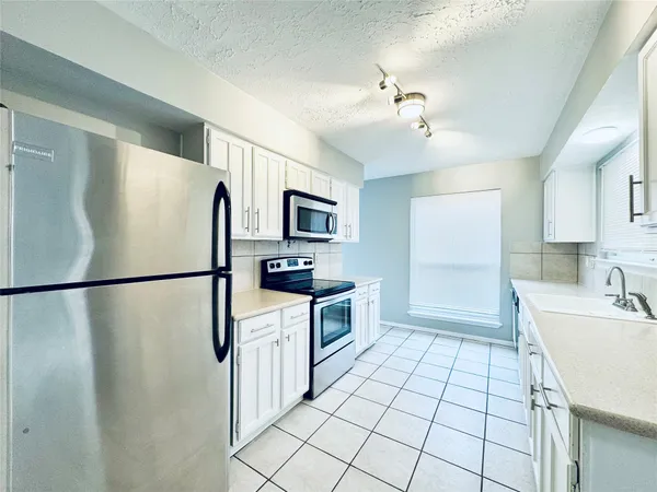 a kitchen with a refrigerator sink stove and microwave