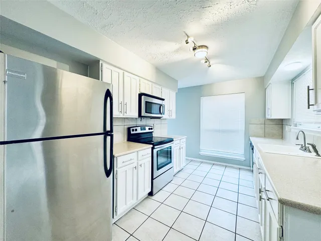 a kitchen with a refrigerator sink stove and microwave