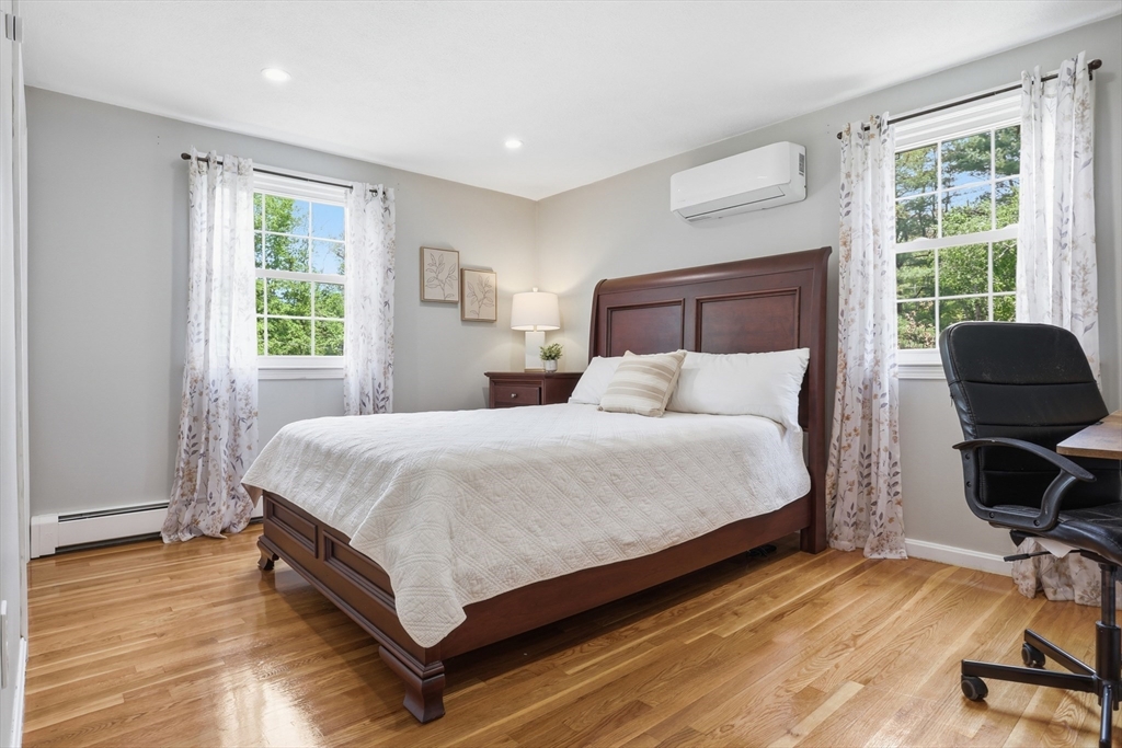 33 Simon Willard Road Acton, MA 01720 - Photo 25 of 42 a bedroom with a bed a chair and a large window