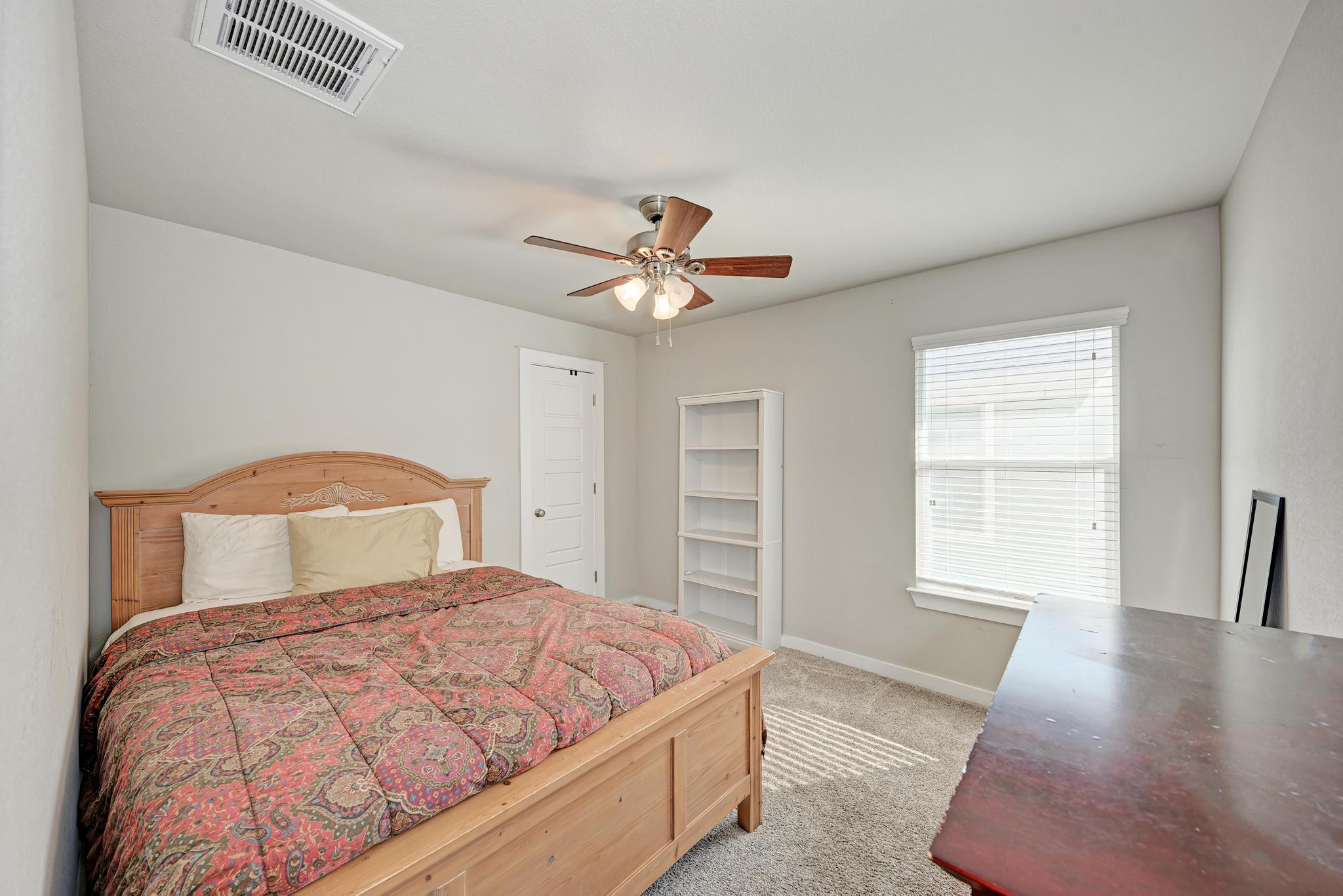 5305 Ingersoll Lane Austin, TX 78744 - Photo 21 of 27 a bedroom with a large bed and a chandelier