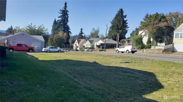 a view of a house with a big yard and palm trees