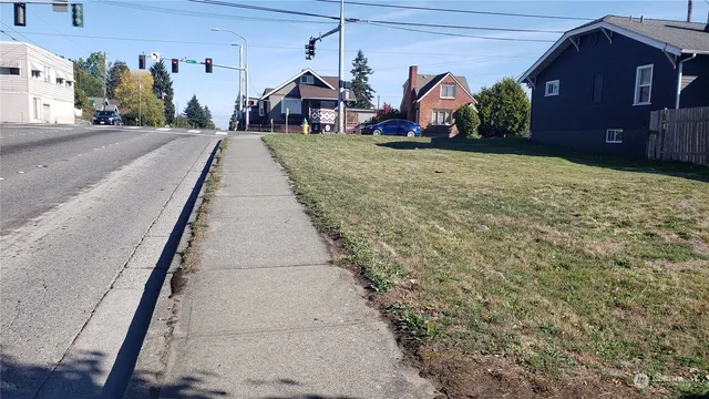 a view of a town with large trees and cars park