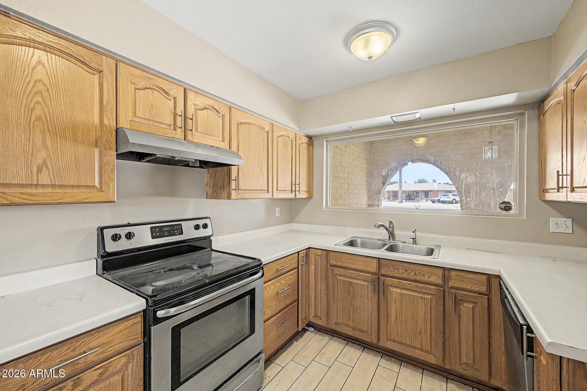 4007 West Mountain View Road Phoenix, AZ 85051 - Photo 14 of 31 a kitchen with granite countertop a sink cabinets stainless steel appliances and a window