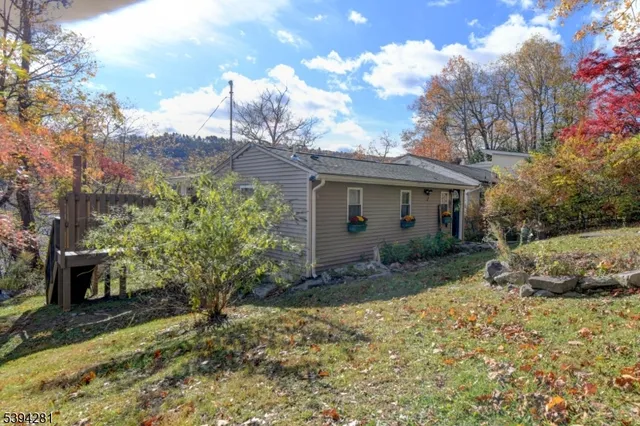 a view of a house with a yard and large tree