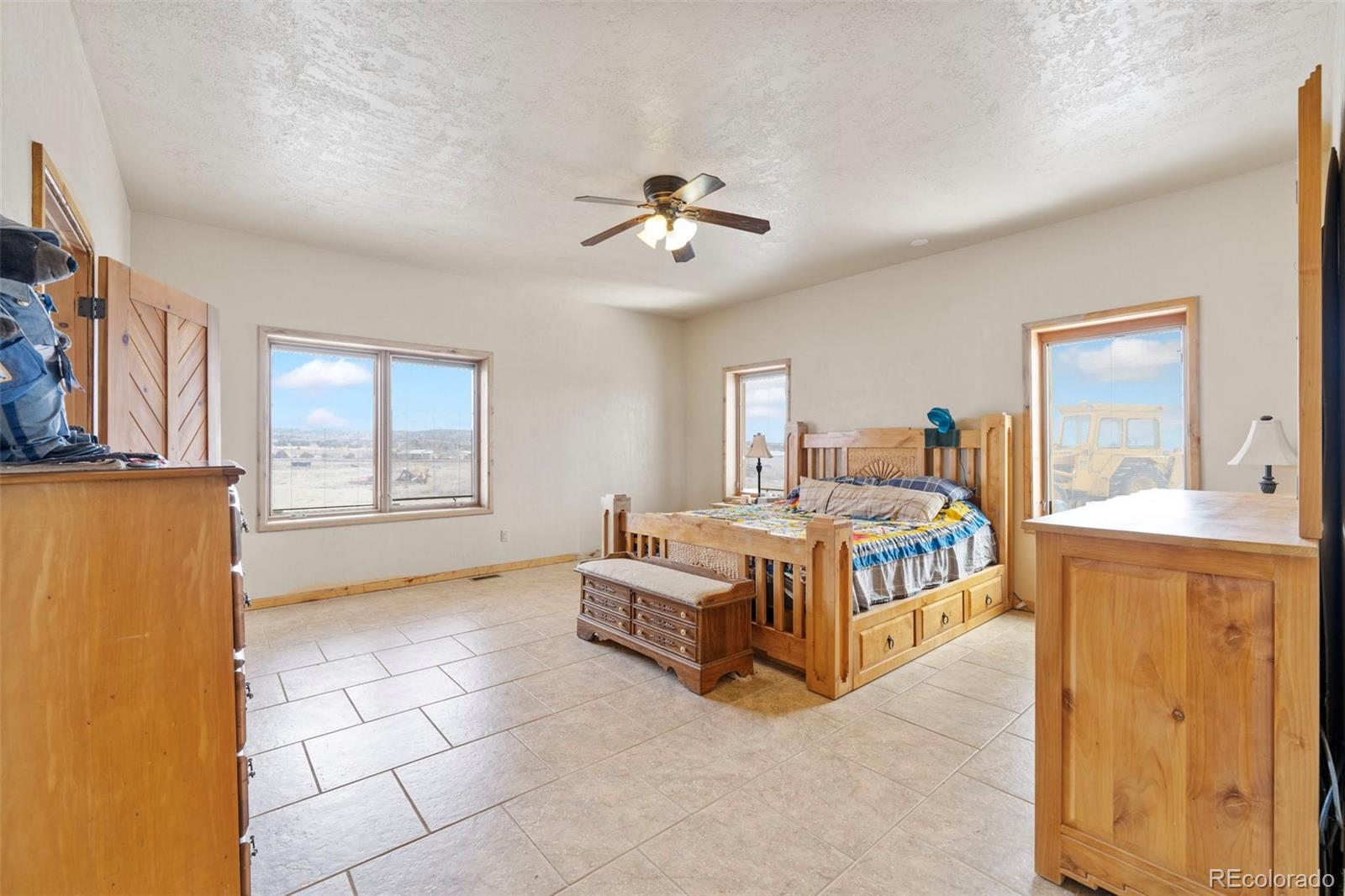 988 P Street Penrose, CO 81240 - Photo 11 of 48 a spacious bedroom with a bed and a chandelier