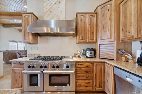 a kitchen with stainless steel appliances granite countertop a sink a stove and a refrigerator