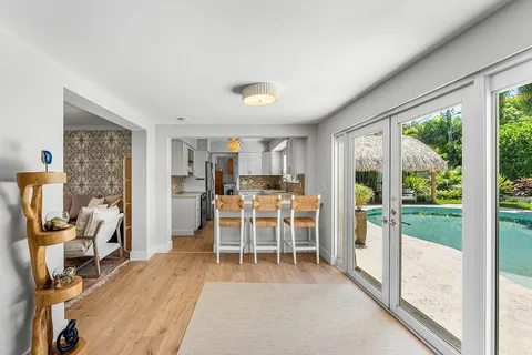 a dining room with furniture water view and a floor to ceiling window