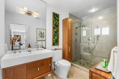 a bathroom with a granite countertop sink a toilet and shower