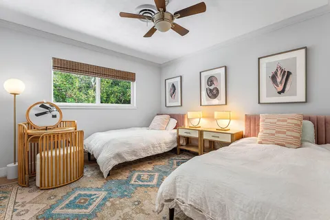 a bedroom with two beds and painting on the wall