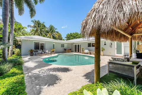 a front view of a house with a yard and potted plants