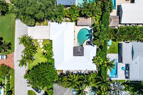 an aerial view of residential houses with outdoor space and trees