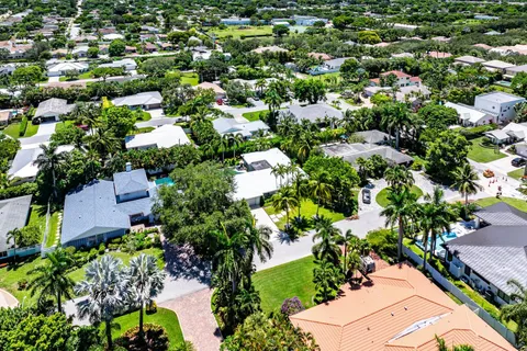 an aerial view of residential houses with outdoor space and trees all around
