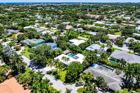an aerial view of residential houses with outdoor space and trees
