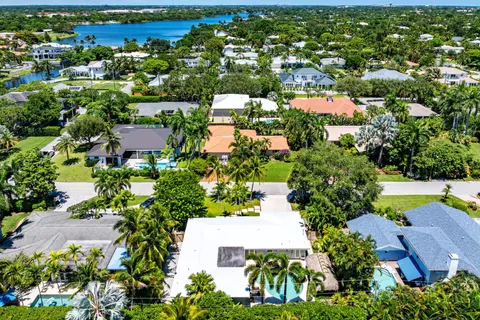 an aerial view of residential houses with outdoor space and trees all around