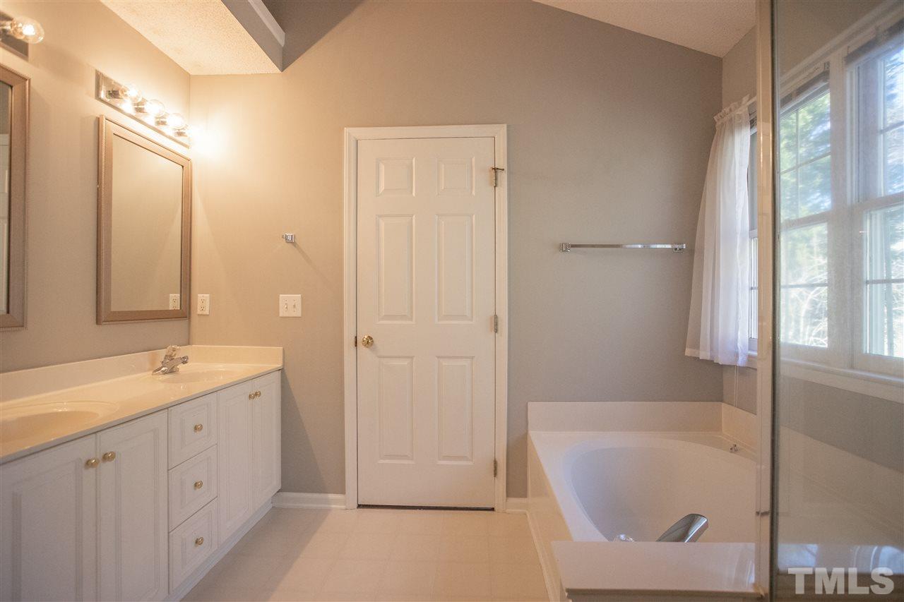5212 Halcott Court Raleigh, NC 27613 - Photo 14 of 27 a spacious bathroom with a tub sink and mirror