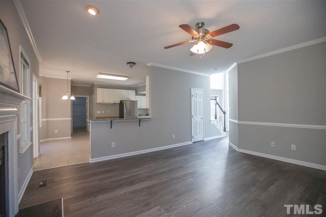 5212 Halcott Court Raleigh, NC 27613 - Photo 8 of 27 a view of an empty room with wooden floor and a ceiling fan