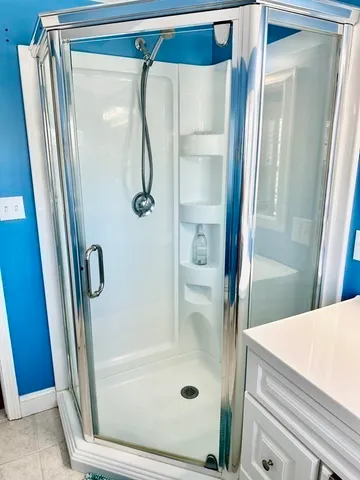 a bathroom with a glass door shower and a sink