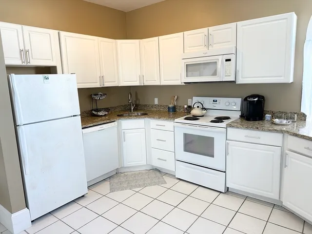 a kitchen with white cabinets and white appliances