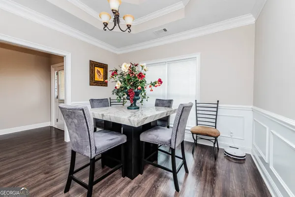 a dining room with furniture potted plants and wooden floor