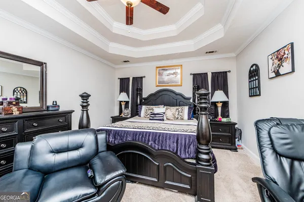 a bed room with a bed a dresser and a chandelier
