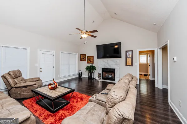a living room with furniture a fireplace and a flat screen tv