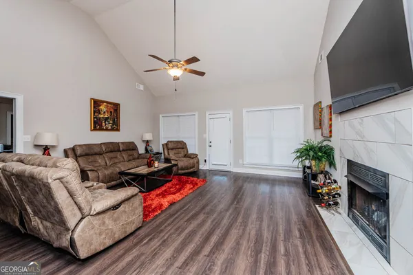 a living room with furniture fireplace and wooden floor